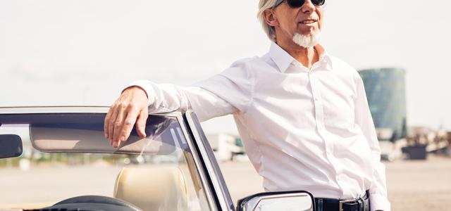 man posing by car